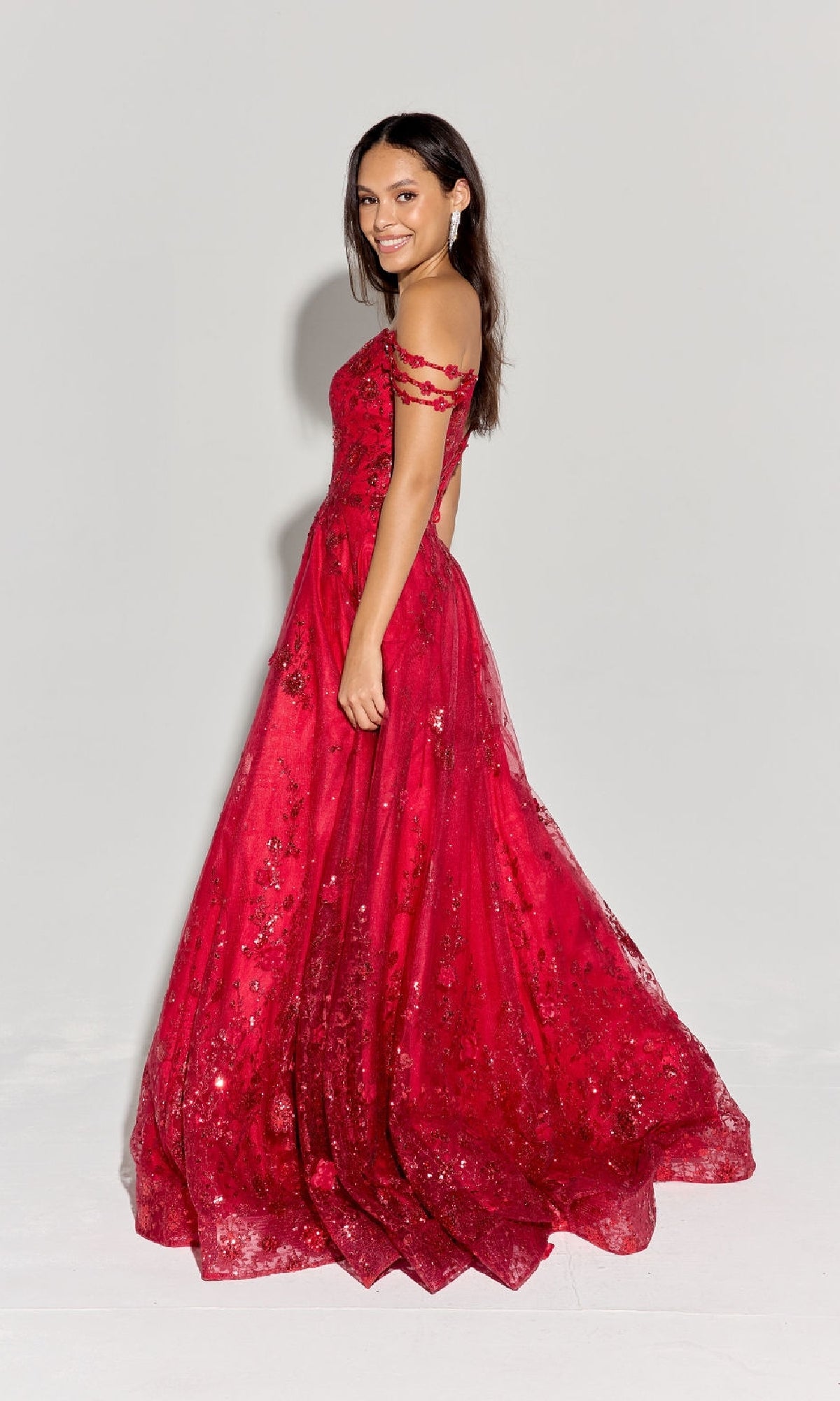 A woman stands in profile wearing the Eureka 9980 Long Glitter-Tuller A-Line Prom Dress with sequin details, posed against a plain light background.
